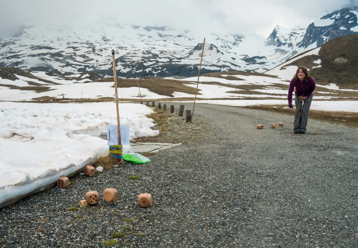 Joueur qui lance le Cochodé sur un chemin de montagne enneigé